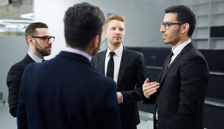 Four businessmen talking in a conference room.