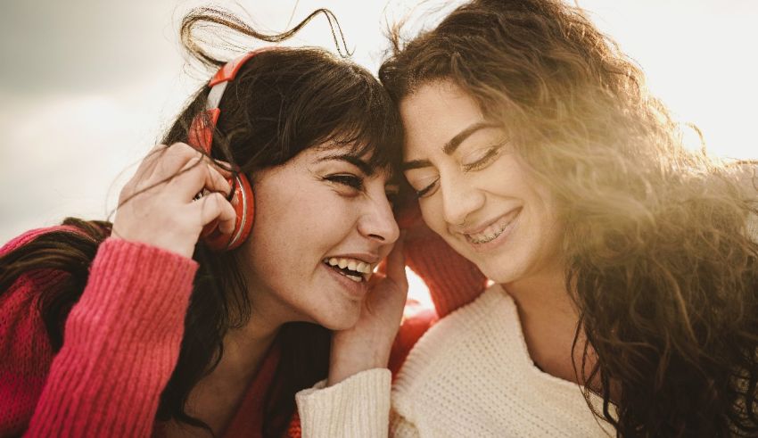Two women laughing while listening to music.