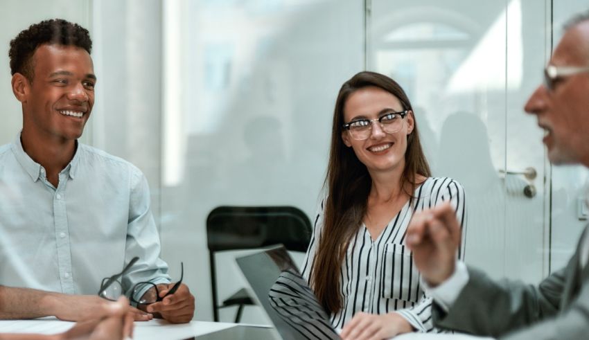 A group of people sitting around a table in an office.