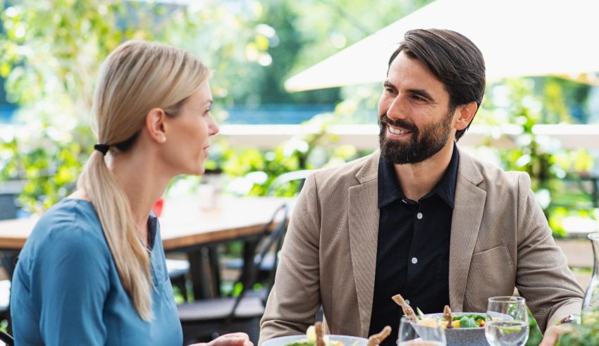 A man and woman are having a conversation at a restaurant.