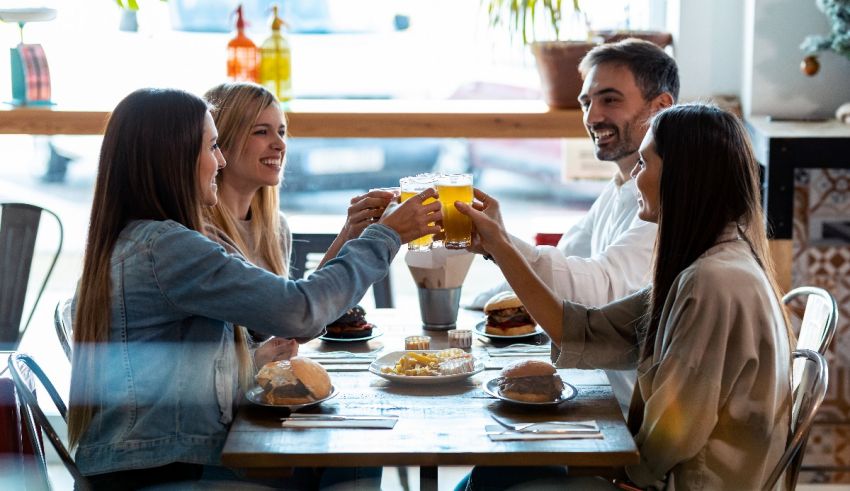 A group of friends toasting at a table in a restaurant.