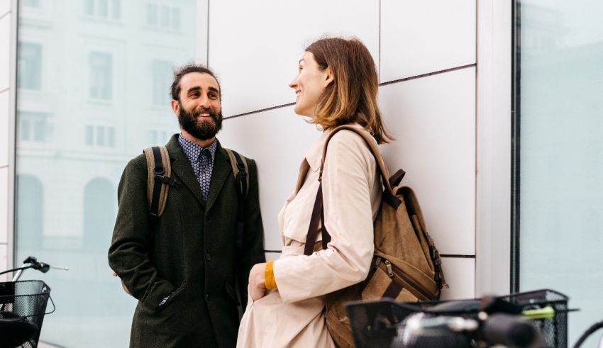 A man and a woman talking in front of a building.