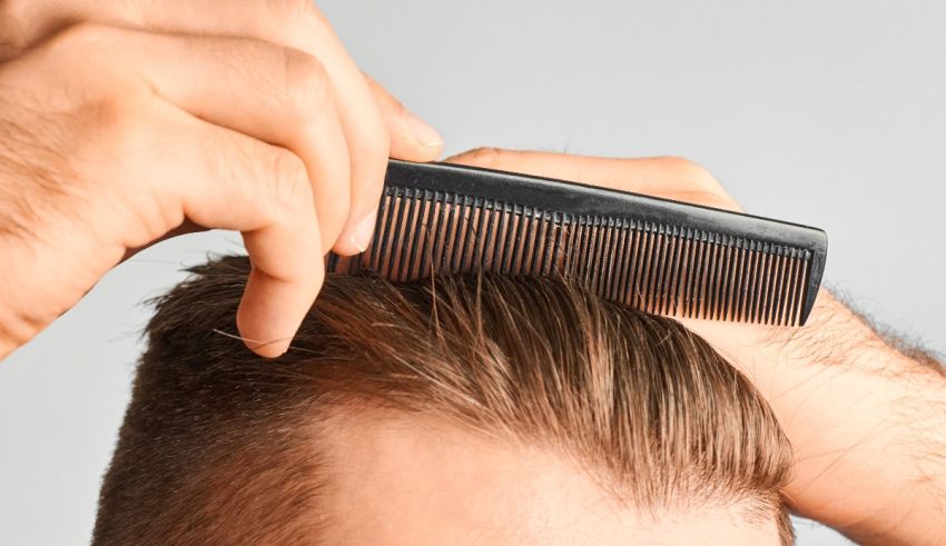 A man is combing his hair with a comb.