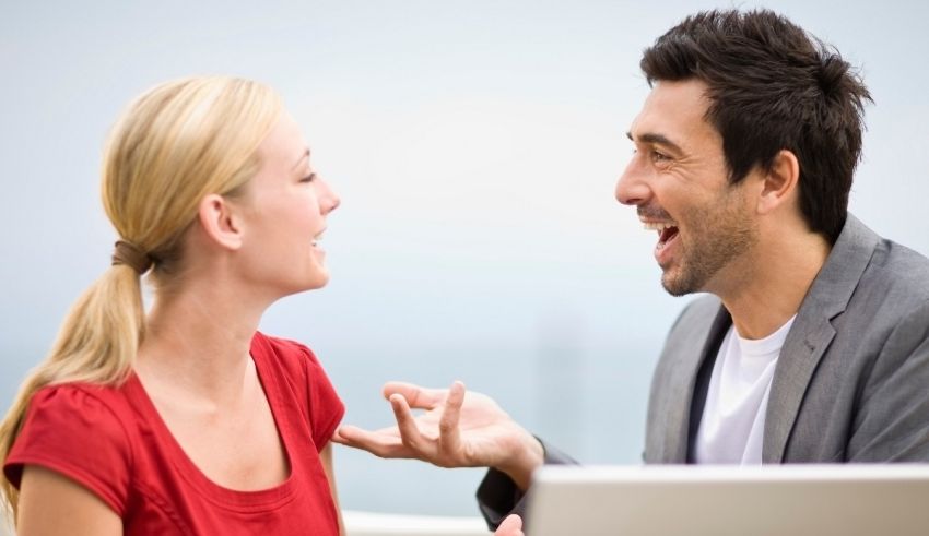 A man and woman are laughing while talking to each other.