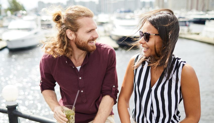 A man and woman are sitting on a dock talking.