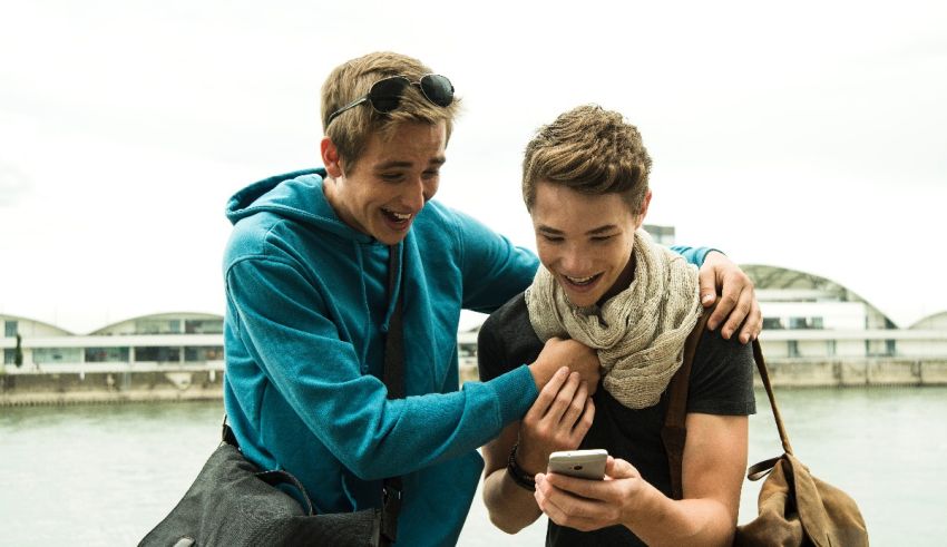 Two young men looking at a cell phone.