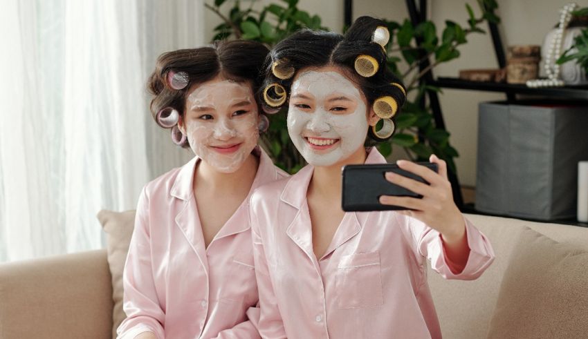 Two asian women taking a selfie while wearing facial masks.