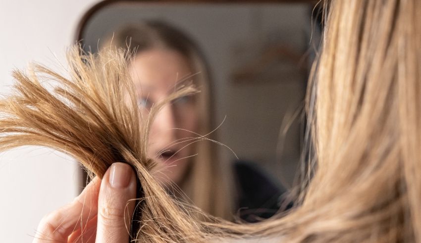A woman is combing her hair in front of a mirror.