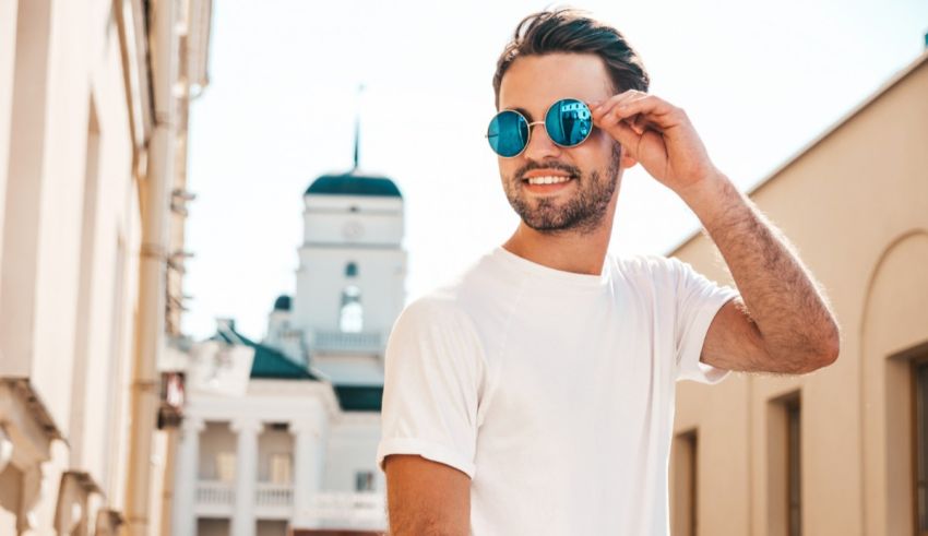 A young man wearing sunglasses on a city street.