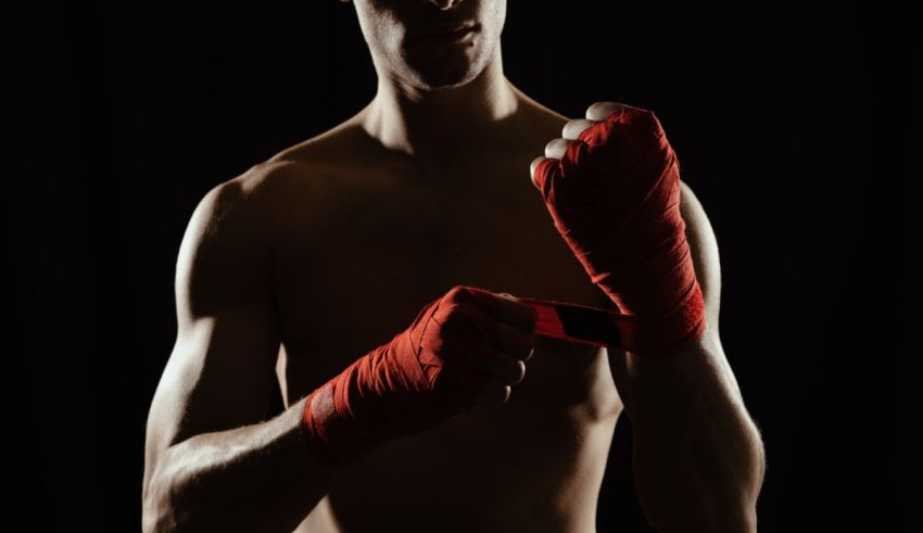 A man in boxing gloves is holding a cell phone.