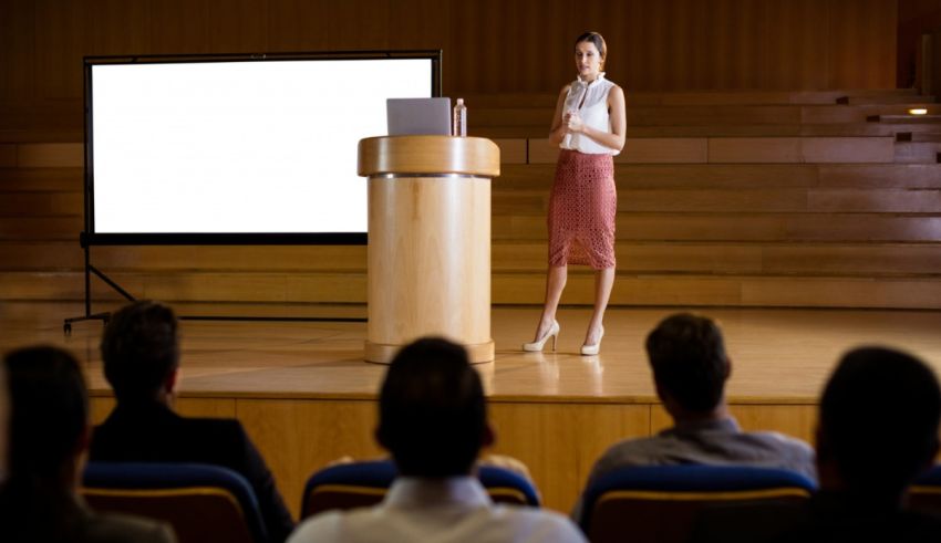 A woman giving a presentation in front of an audience.