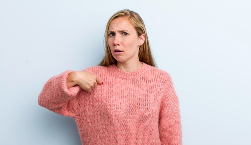 A woman with a pink sweater pointing at her finger.