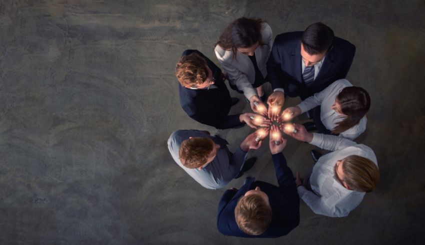 A group of business people holding hands in a circle.