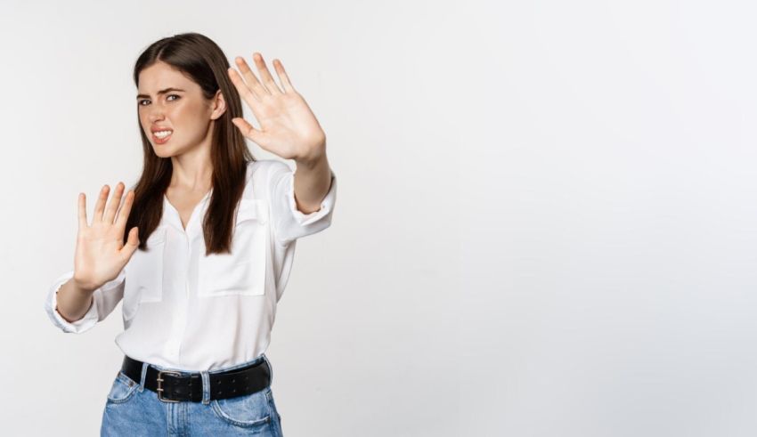 A woman is making a stop gesture on a white background.