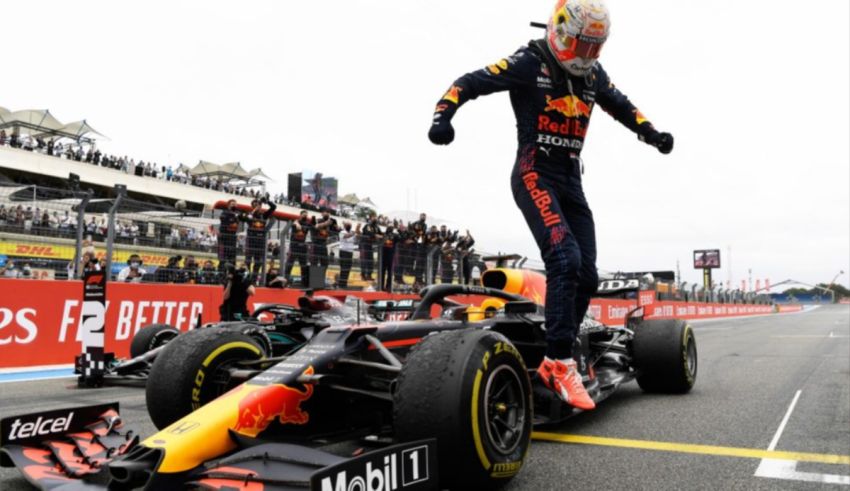 A red bull racing driver celebrates after winning a race.