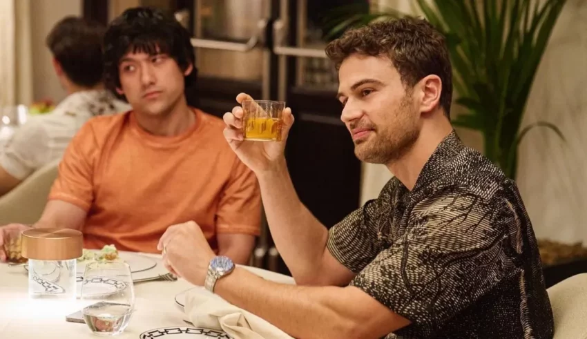 Two men sitting at a table drinking a drink.