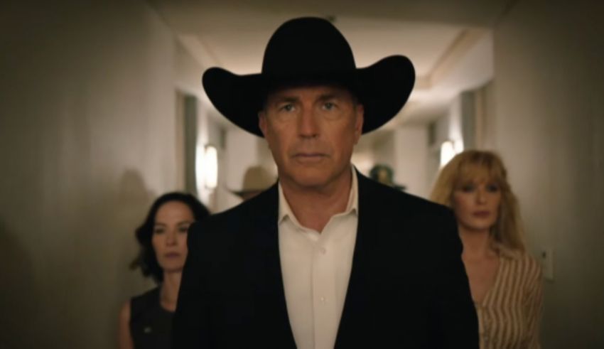A man in a cowboy hat is standing in a hallway.