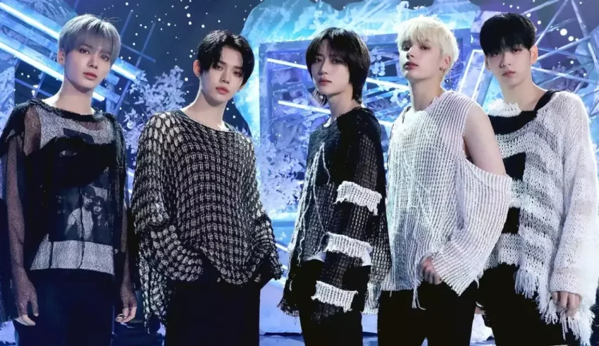 A group of korean boys standing in front of a snowy stage.