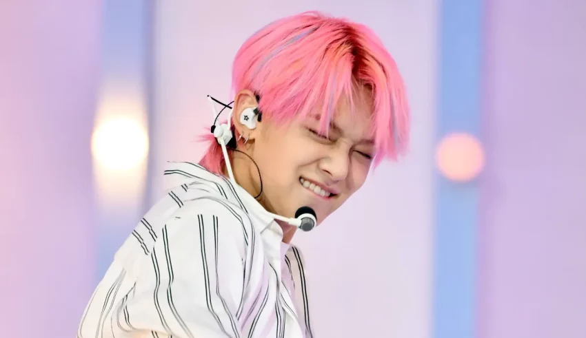 A man with pink hair and a microphone.