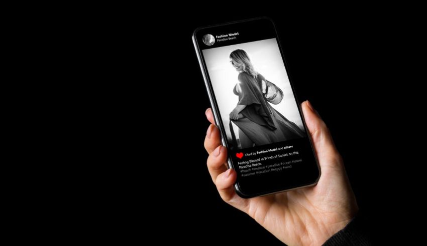 A woman is holding up a phone with a black background.