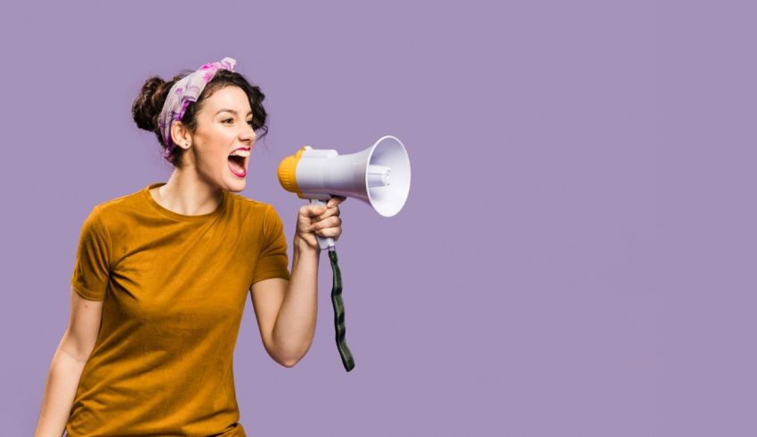 A woman shouting into a megaphone on a purple background.