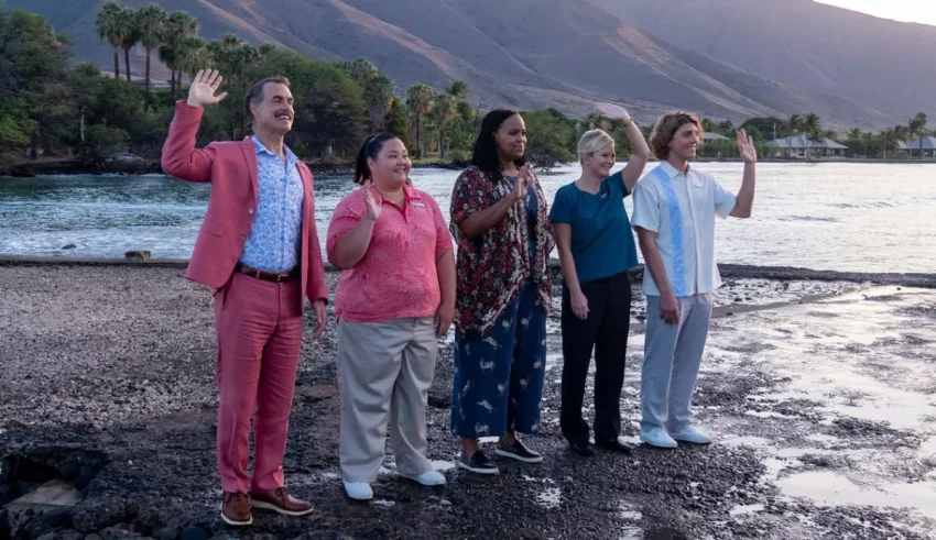 A group of people standing on a beach next to a body of water.