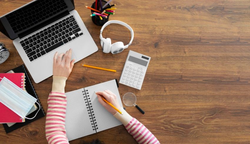 A woman is working on her laptop at a desk.