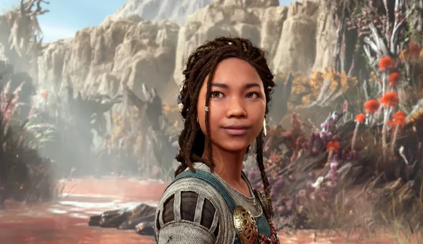 A woman with dreadlocks standing in front of a mountain.