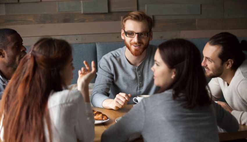 A group of people sitting around a table in a cafe.