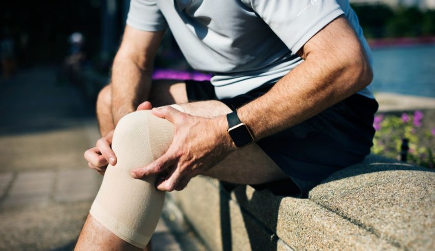 A man with a knee injury sitting on a ledge.