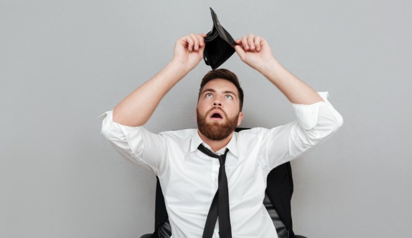 A man sitting in an office chair holding a black wallet.