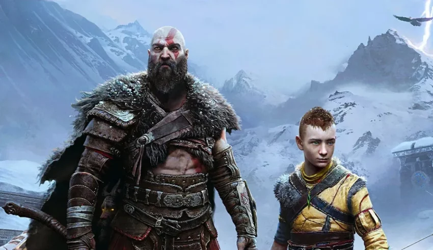 A man and a boy standing in front of a snowy mountain.