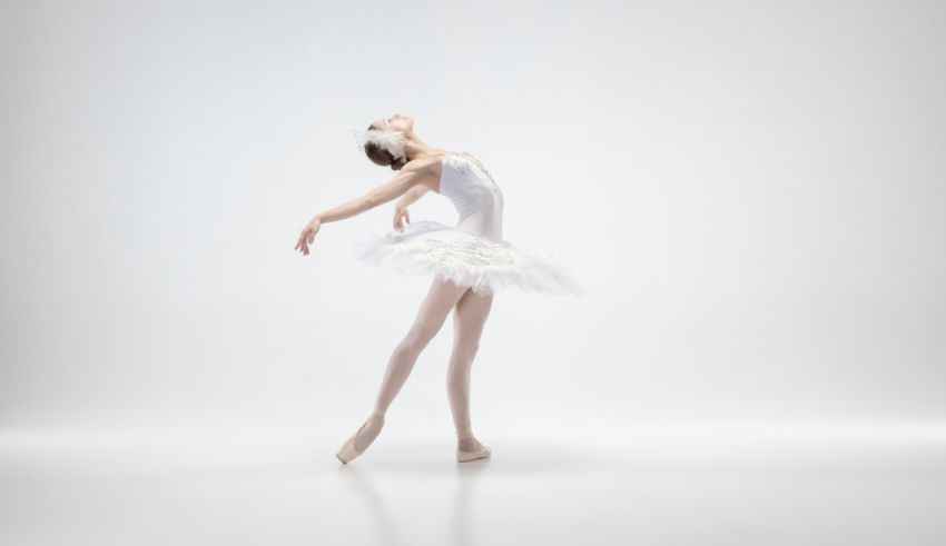 A young ballerina is dancing on a white background.