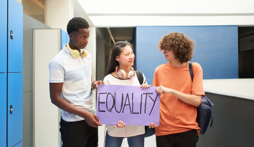 Three young people holding up a sign that says equality.