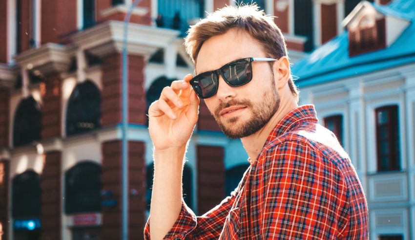 A man in a plaid shirt is wearing sunglasses.