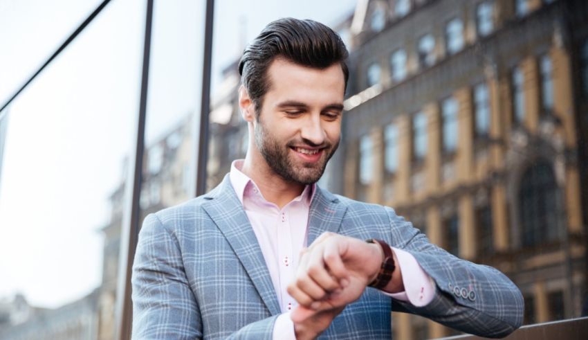 A man in a suit is looking at his watch.