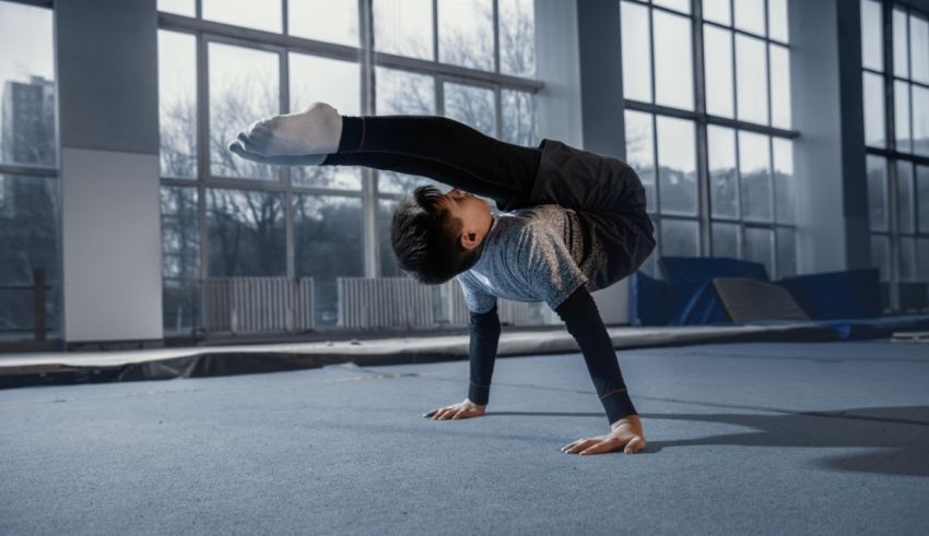 A young gymnast doing a handstand in a gym.