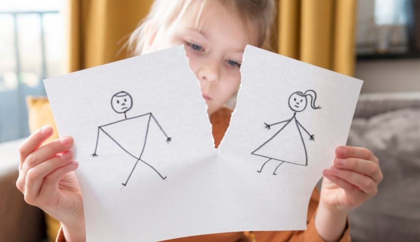 A little girl holding up a piece of paper with a drawing of a man and a woman.