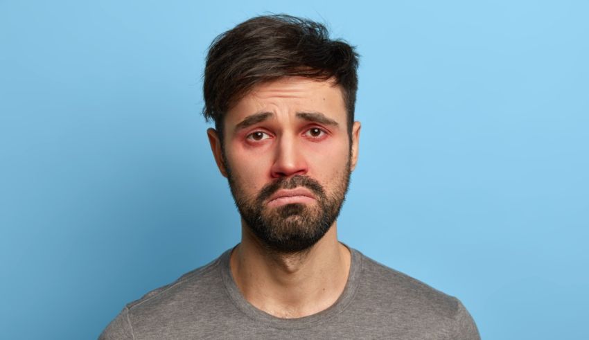 A man with a beard and red face on a blue background.