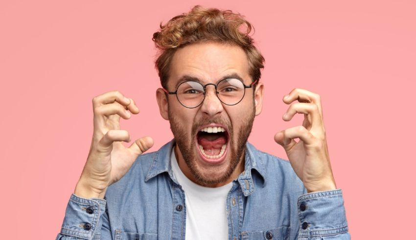 A man with glasses is making a face with his hands.