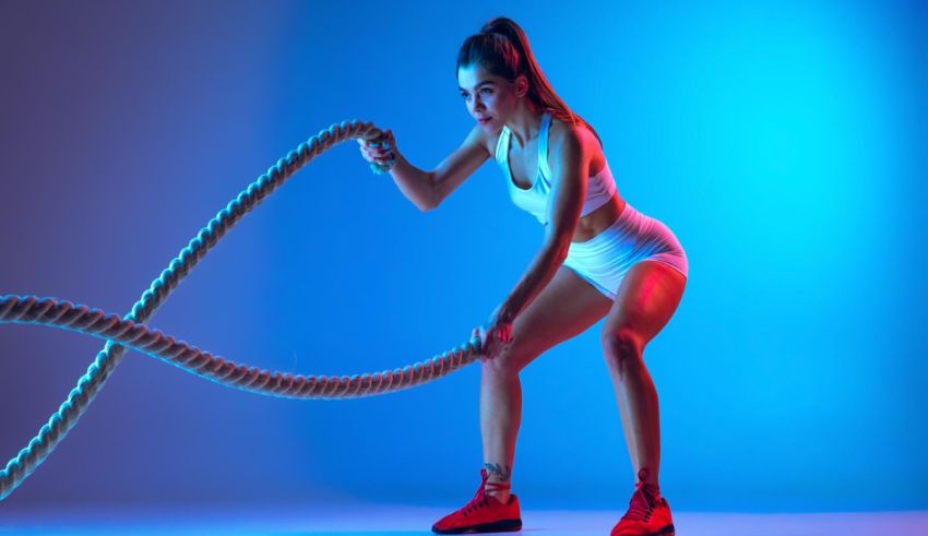 A woman is holding a rope on a blue background.