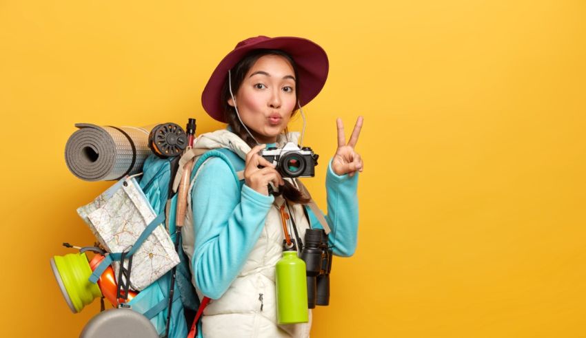 A woman with a backpack holding a peace sign.