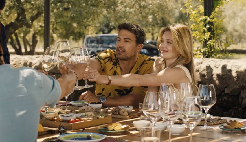 A group of people toasting wine glasses at an outdoor table.