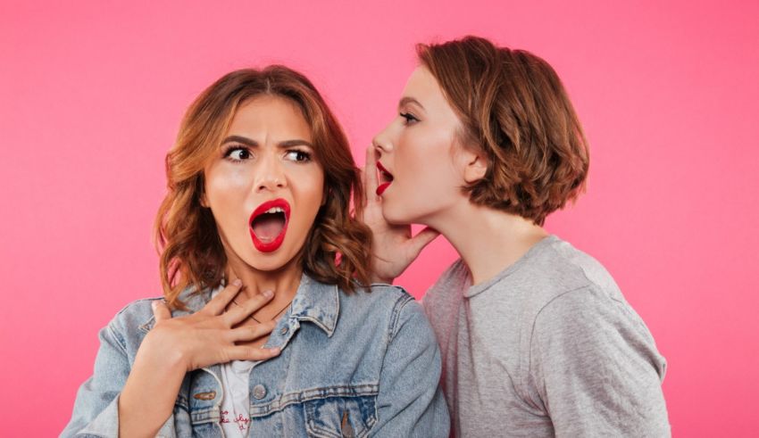 A woman is yelling at a man in front of a pink background.