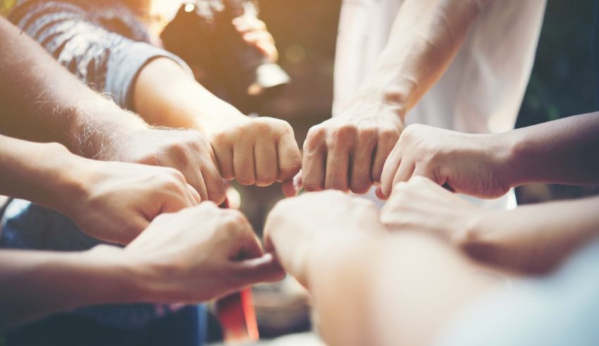 A group of people putting their hands together in a circle.