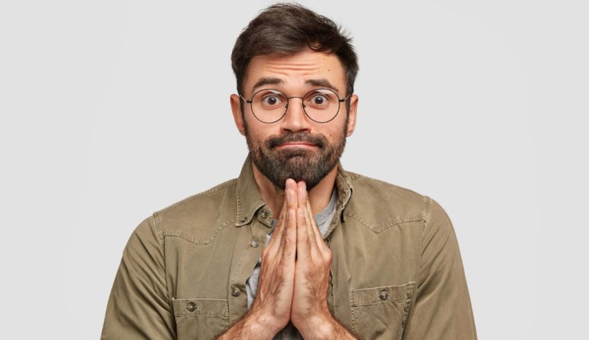 A man with glasses and a beard is making a surprise gesture.