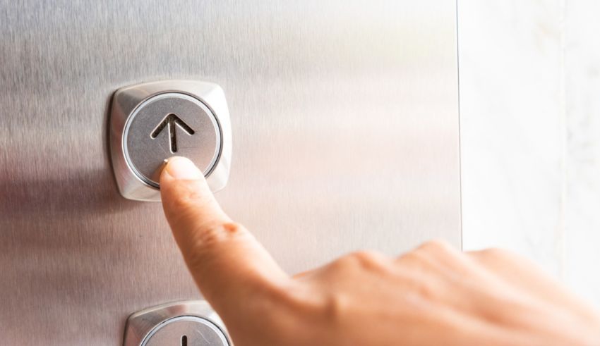 A woman's hand is pressing an elevator button.