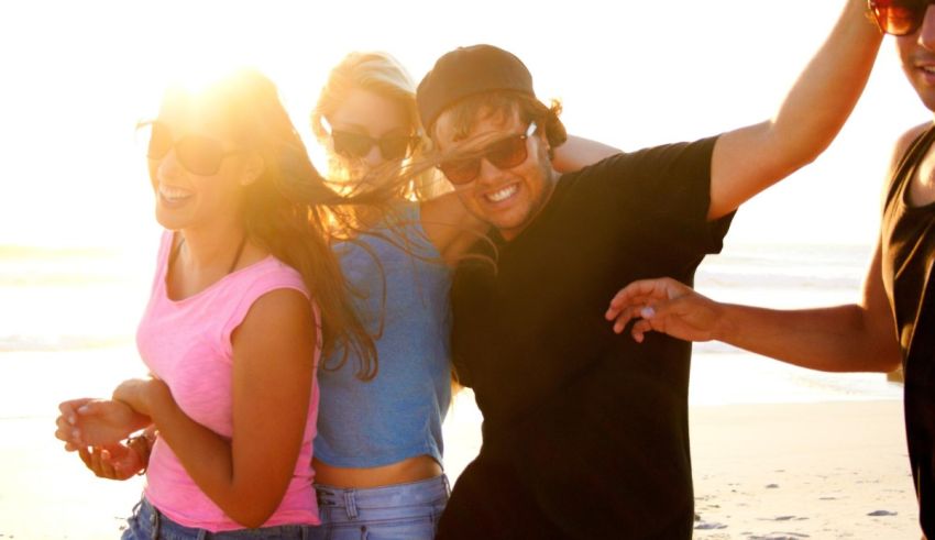 A group of friends dancing on the beach.