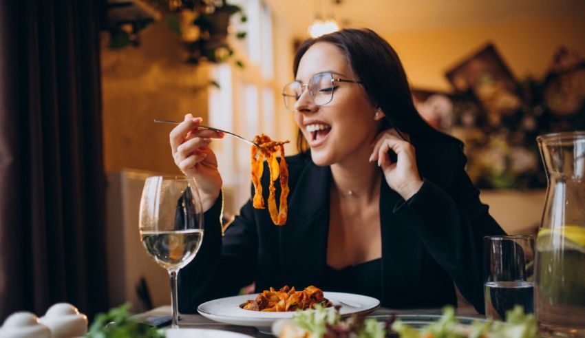 A woman eating spaghetti in a restaurant.