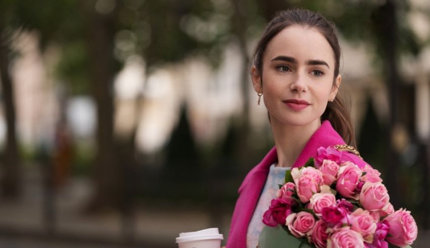 A young woman holding a bouquet of pink roses.